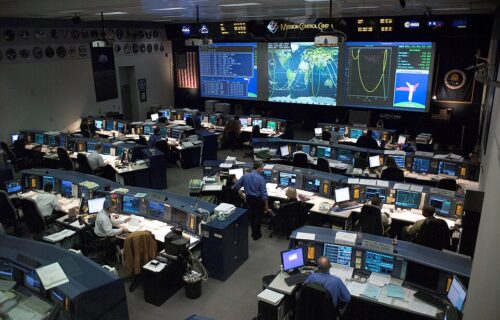 Mission control room with people and computer systems coordinating an operation.